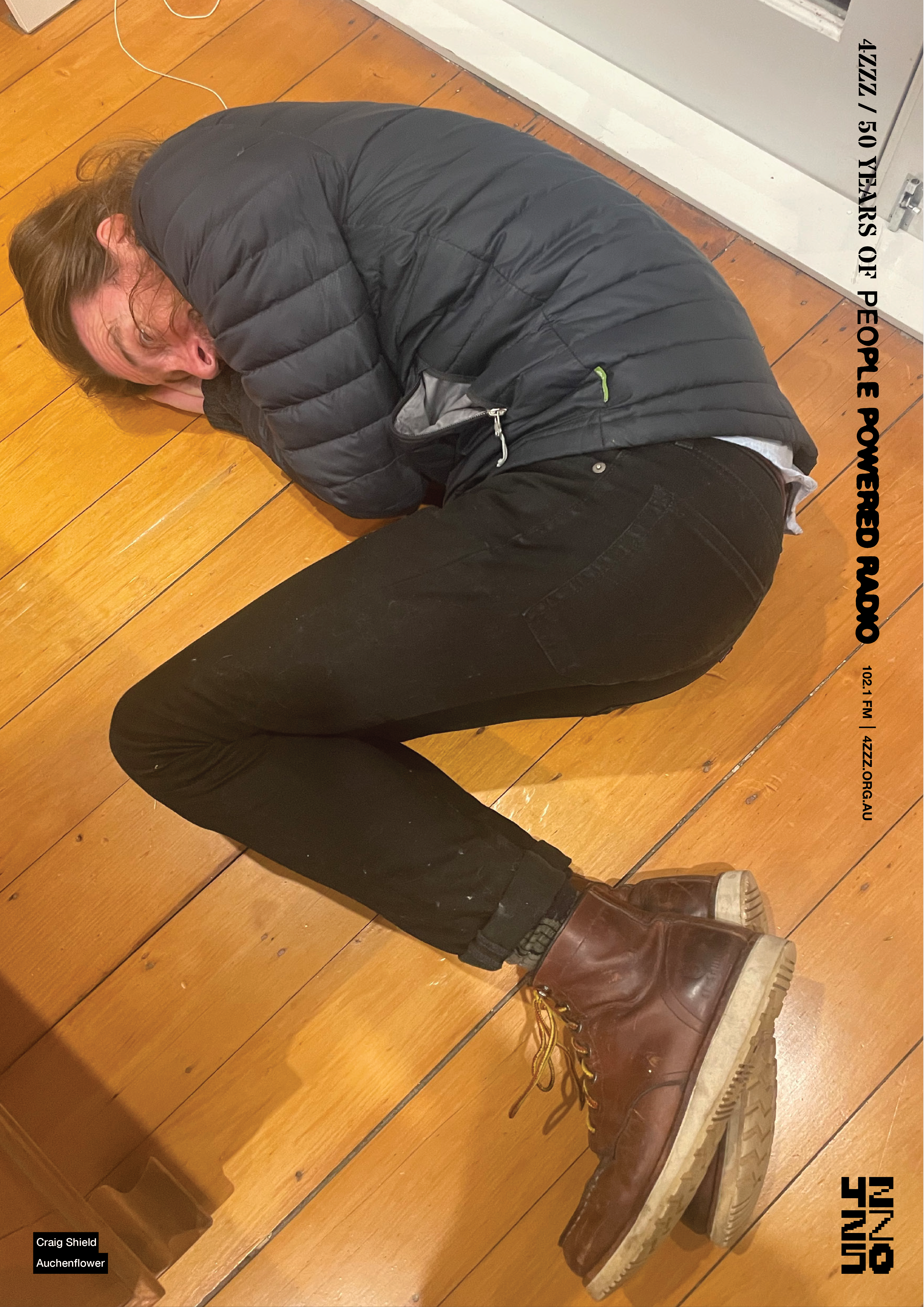 A very obliging individual lying on the wooden kitchen floor, their body held in the shape of a Z. 