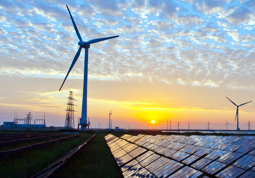 A field showcasing windmills and solar panels