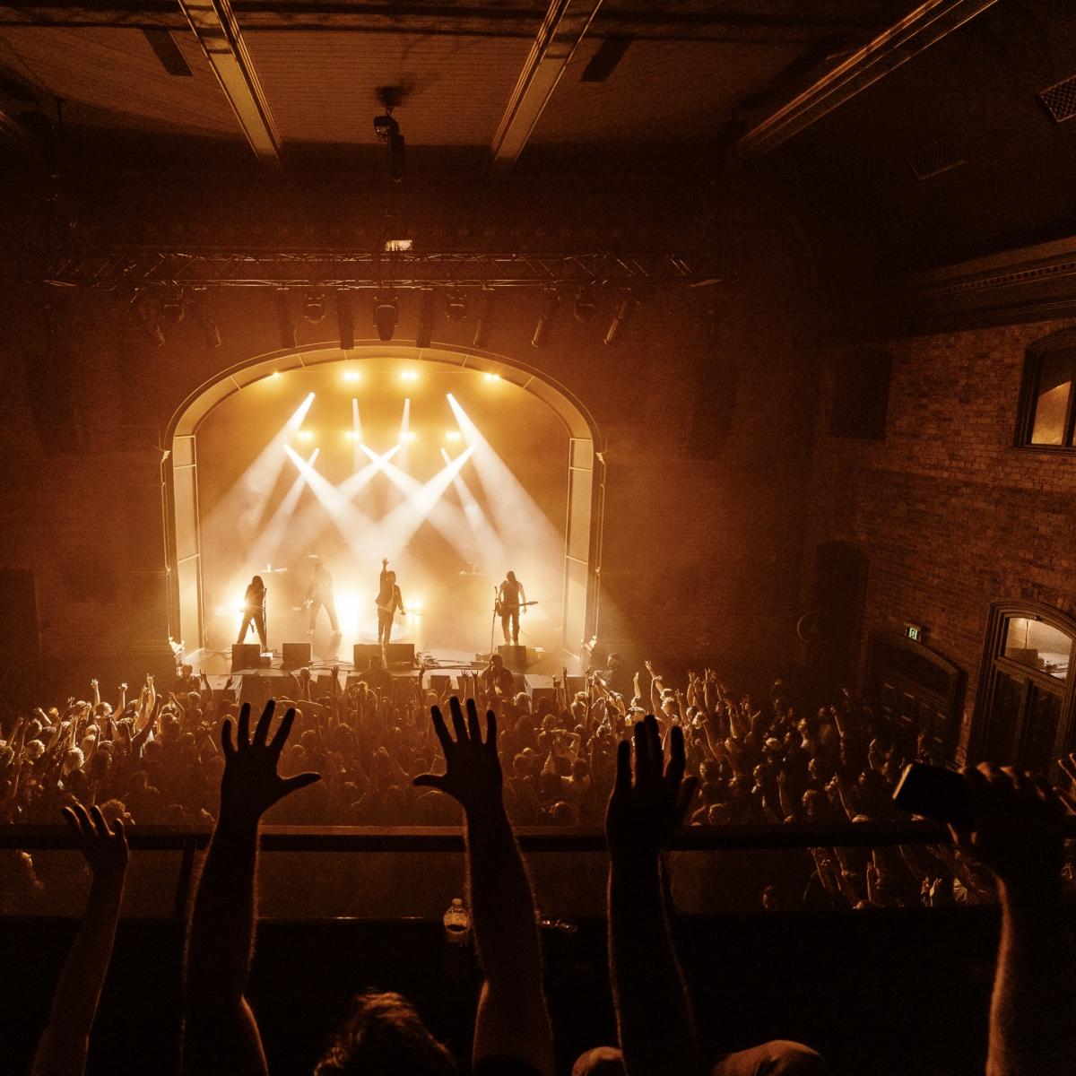 Inside the Princess Theatre during a show and people have their hands up 