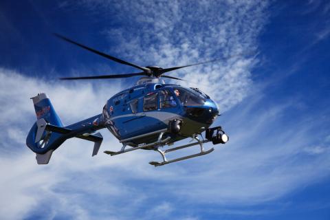 Image of a helicopter against a cloudy blue sky