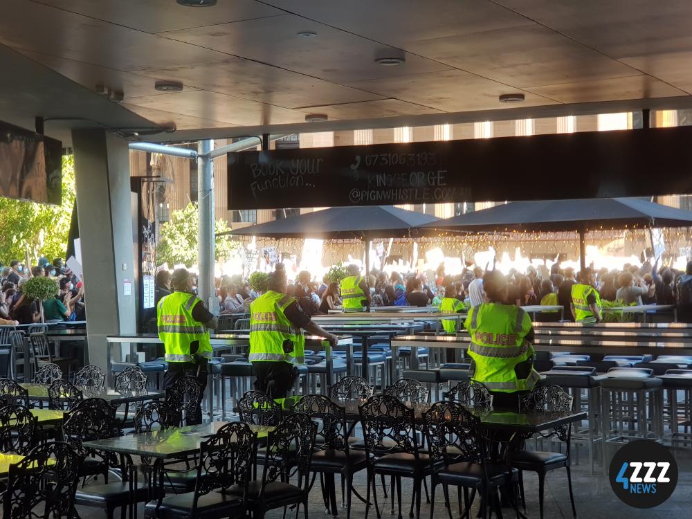 BLM Rally - Police watching on from a restaurant on King George Square [4ZZZ/Alexis Pink]