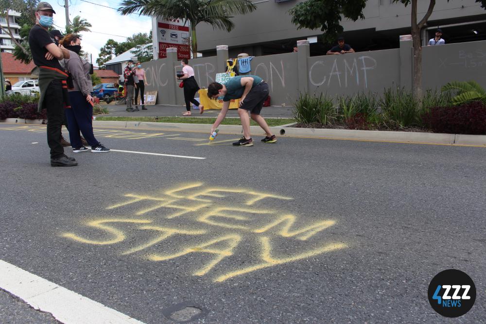 Protesters use chalk and spray paint to write messages of support on the road. [4ZZZ/Lillian Rangiah]